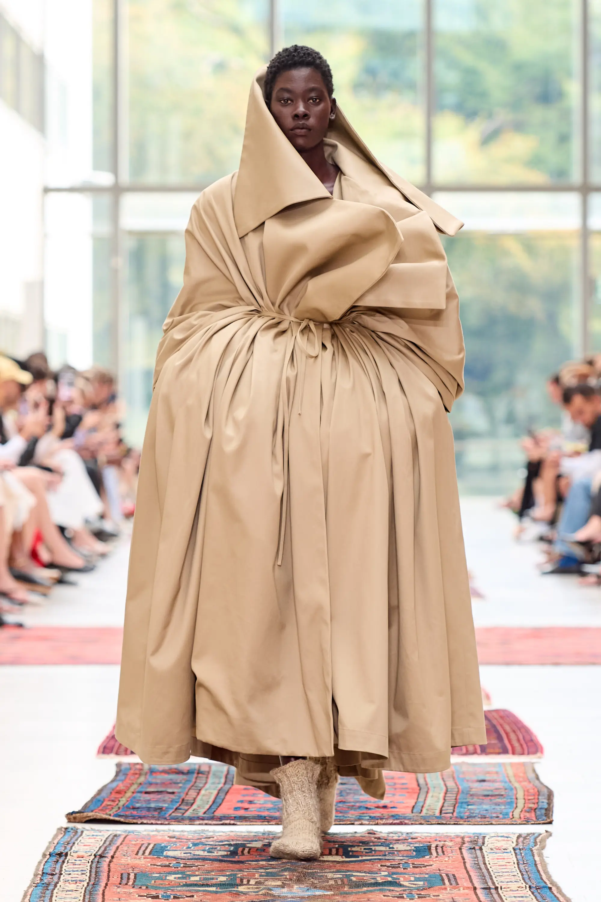 A sculptural beige Institution silhouette with gathered volume and a dramatic collar on the Copenhagen Fashion Week runway